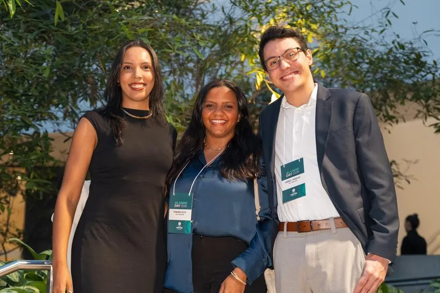 Três participantes posando no Alumni Day do Einstein
