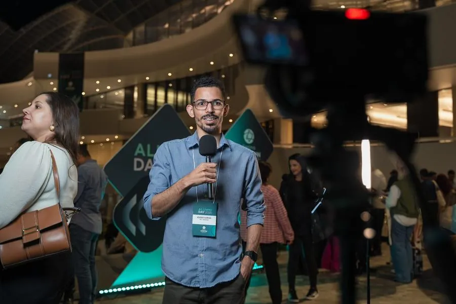 Entrevistador com microfone durante o Alumni Day do Einstein