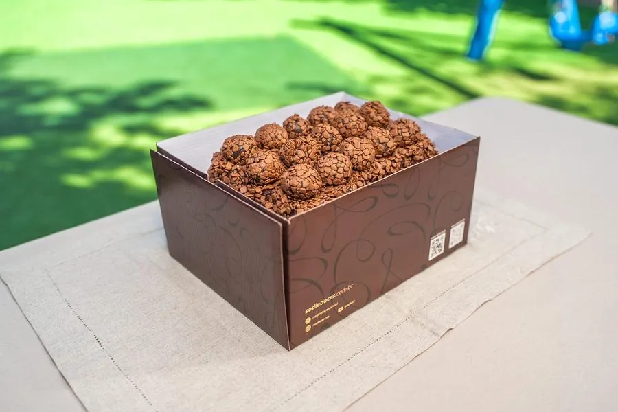 Caixa de brigadeiros da Sodiê Doces sobre a mesa ao ar livre