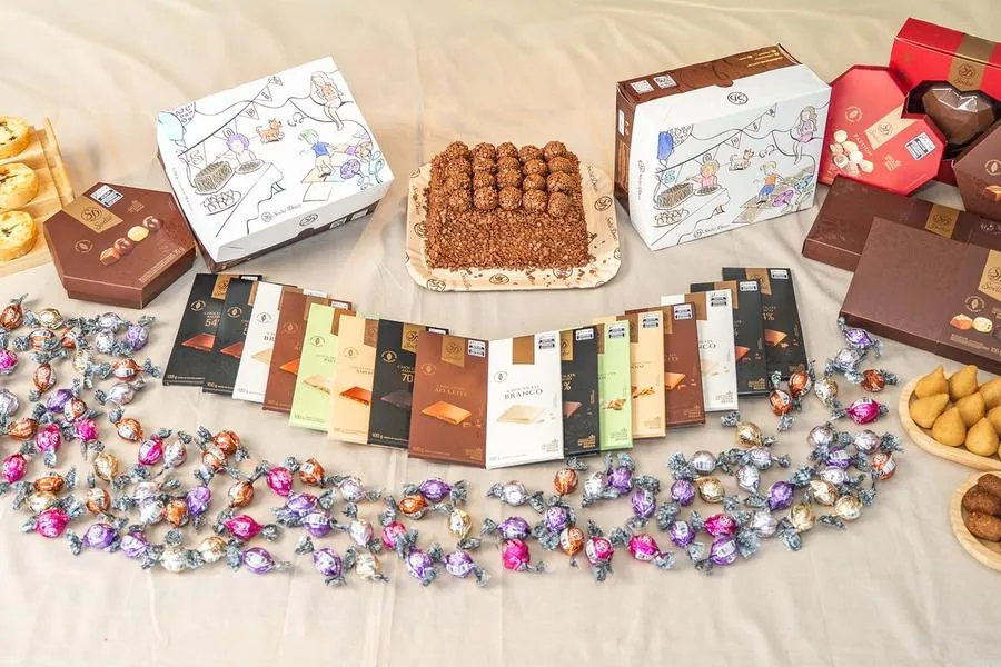 Mesa com bolo, chocolates e doces da Sodiê Doces
