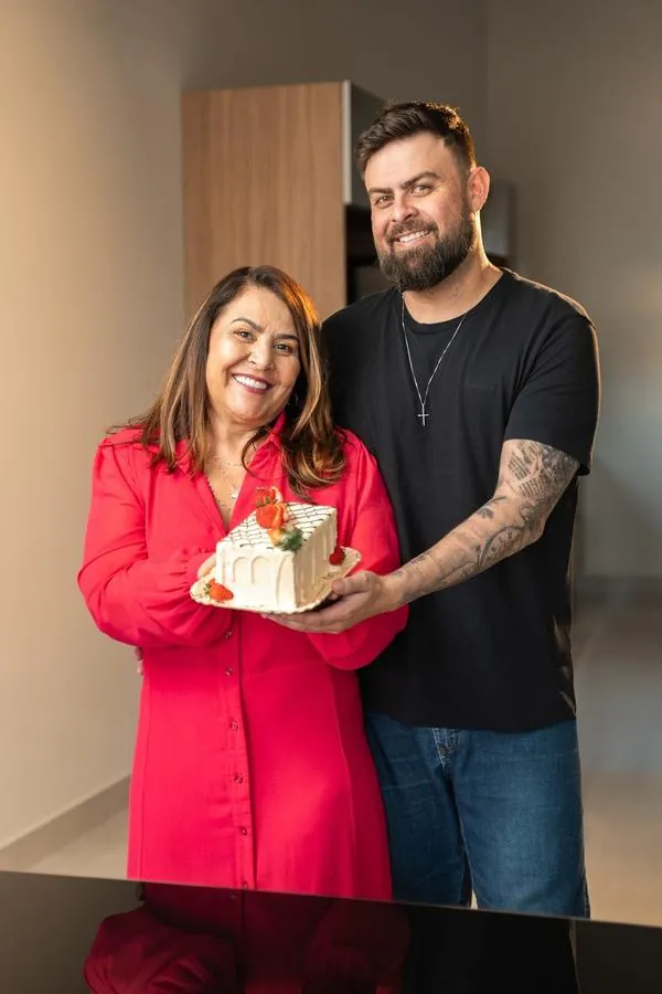 Retrato de duas pessoas segurando um bolo da Sodiê Doces
