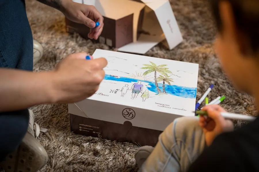 Detalhe de desenho de praia feito à mão em caixa da Sodiê Doces