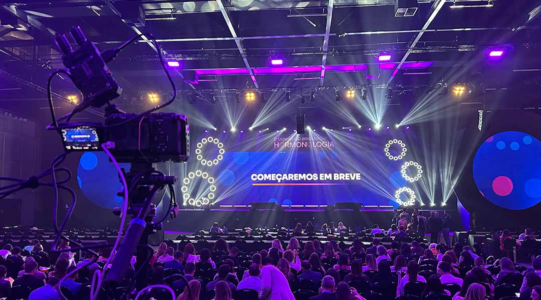 Evento corporativo transmitido ao vivo pela Rolê Filmes em São Paulo, com público, palco e câmeras.
